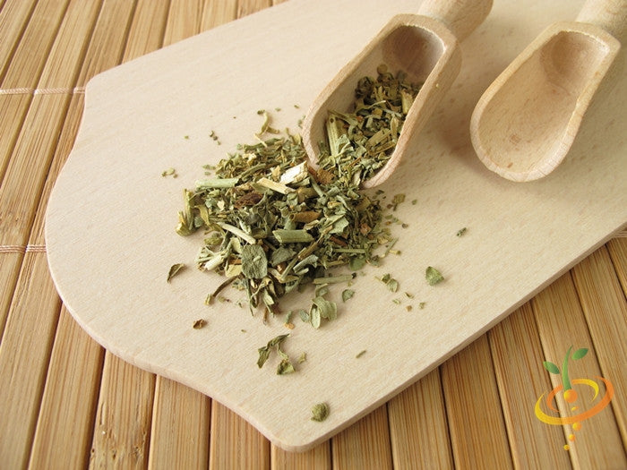 Close-up of dried rue seeds and leaves on a wooden board with wooden scoops